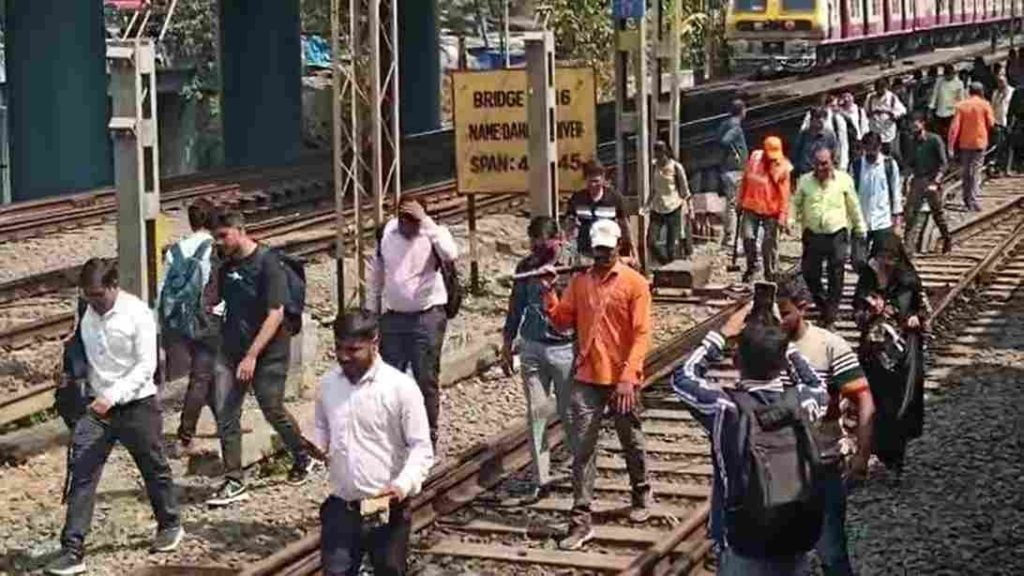 Mumbai: Stranded passengers walk on tracks near Borivali